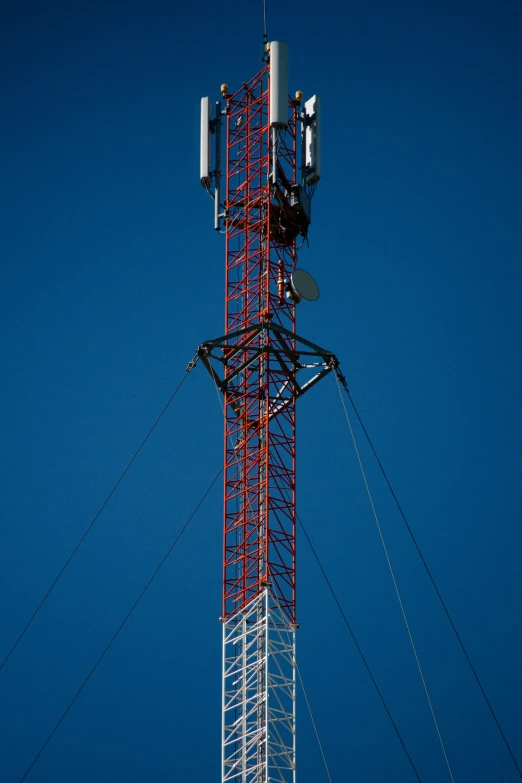 a cell phone tower is set against a clear blue sky