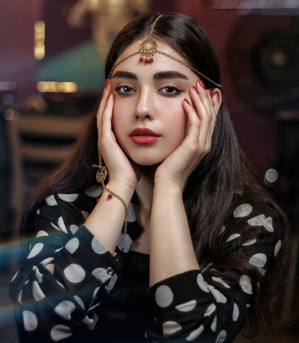 an asian woman with dark hair and head jewelry is leaning on a table