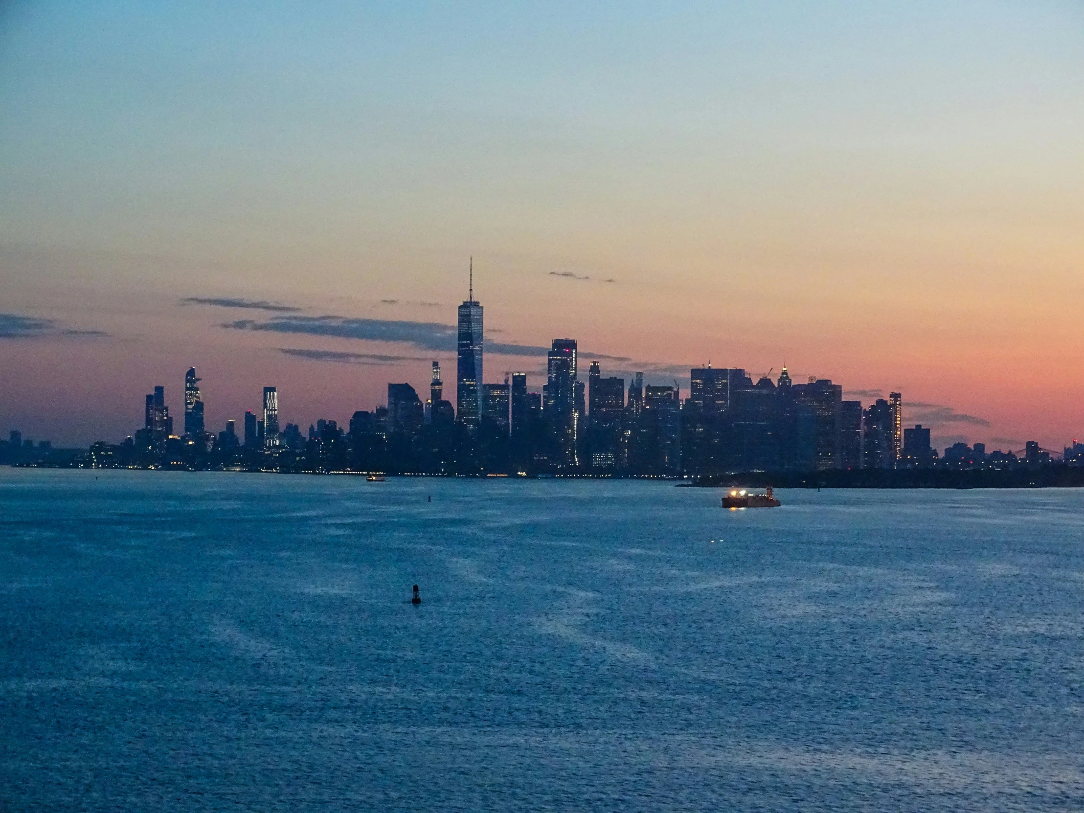 a large body of water with a city skyline in the distance