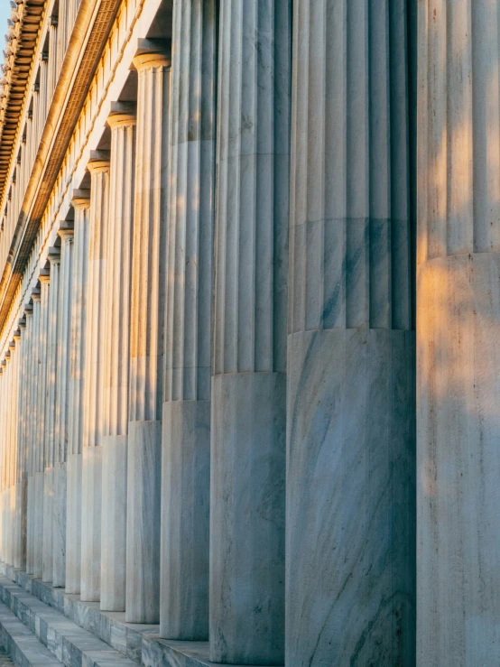 the columns of an old, large building with a sky in the background