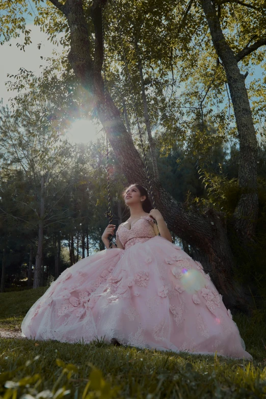 a woman wearing a dress is sitting on grass