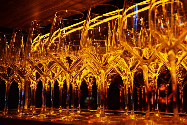 rows of champagne flutes line a bar counter