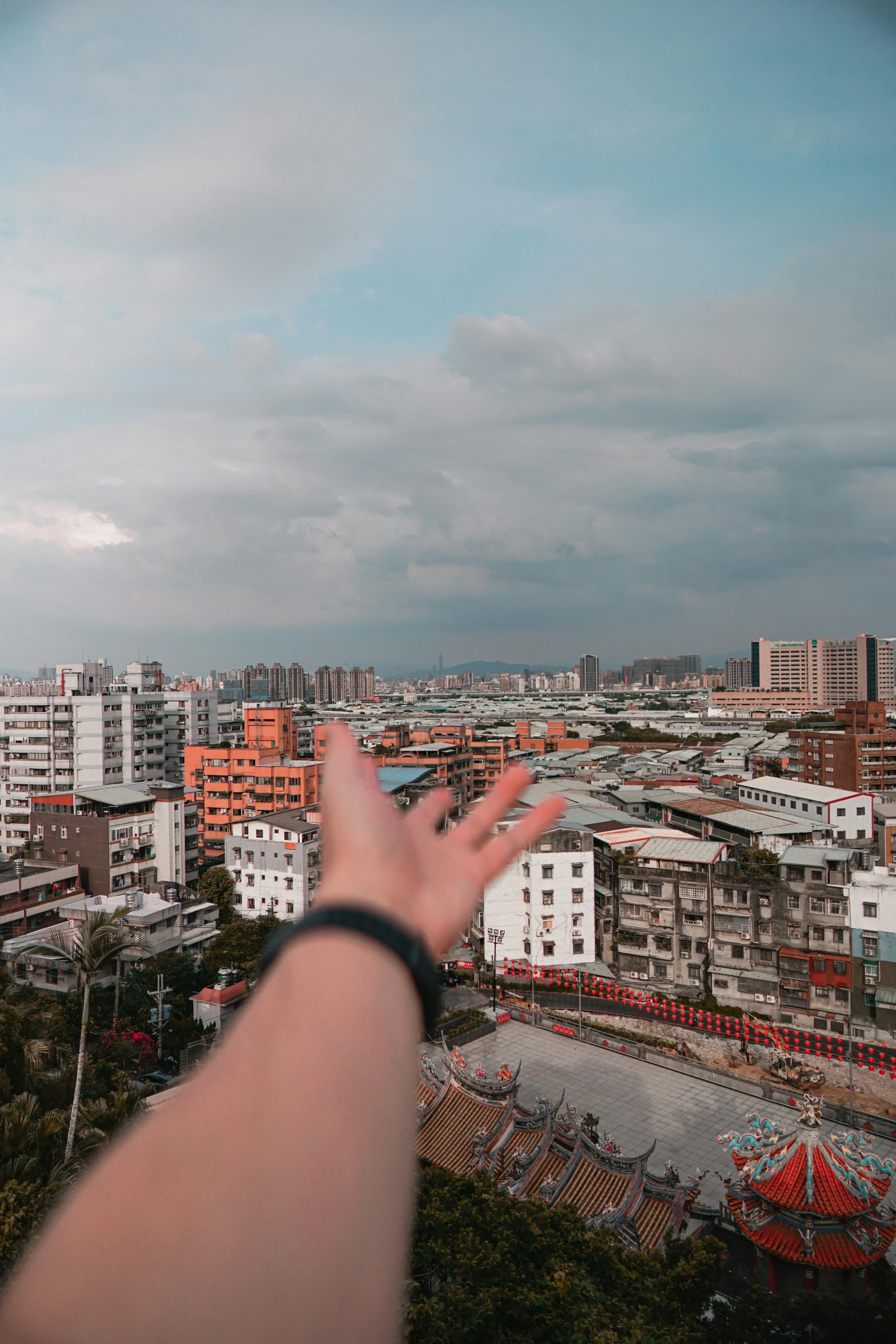 a hand is flying over a city with tall buildings