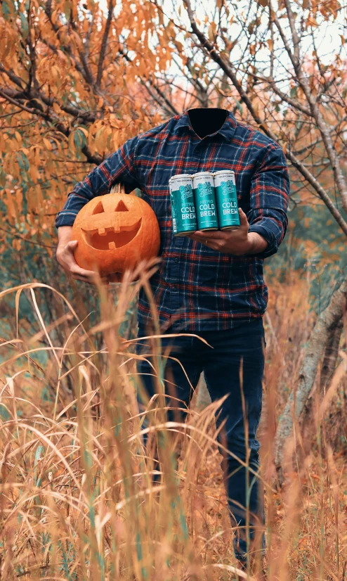 a person holds some beer cans in an overgrown area