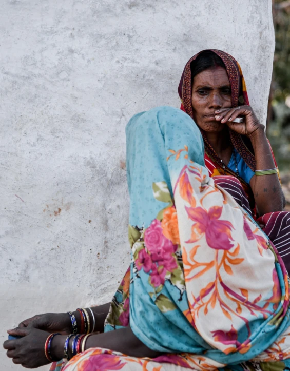 a woman smokes on a cigarette and sits outside