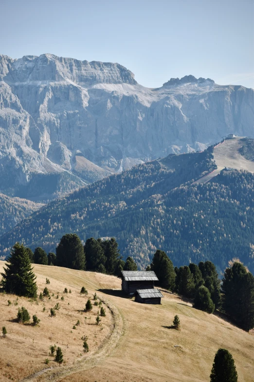 an old cabin in the middle of a large field