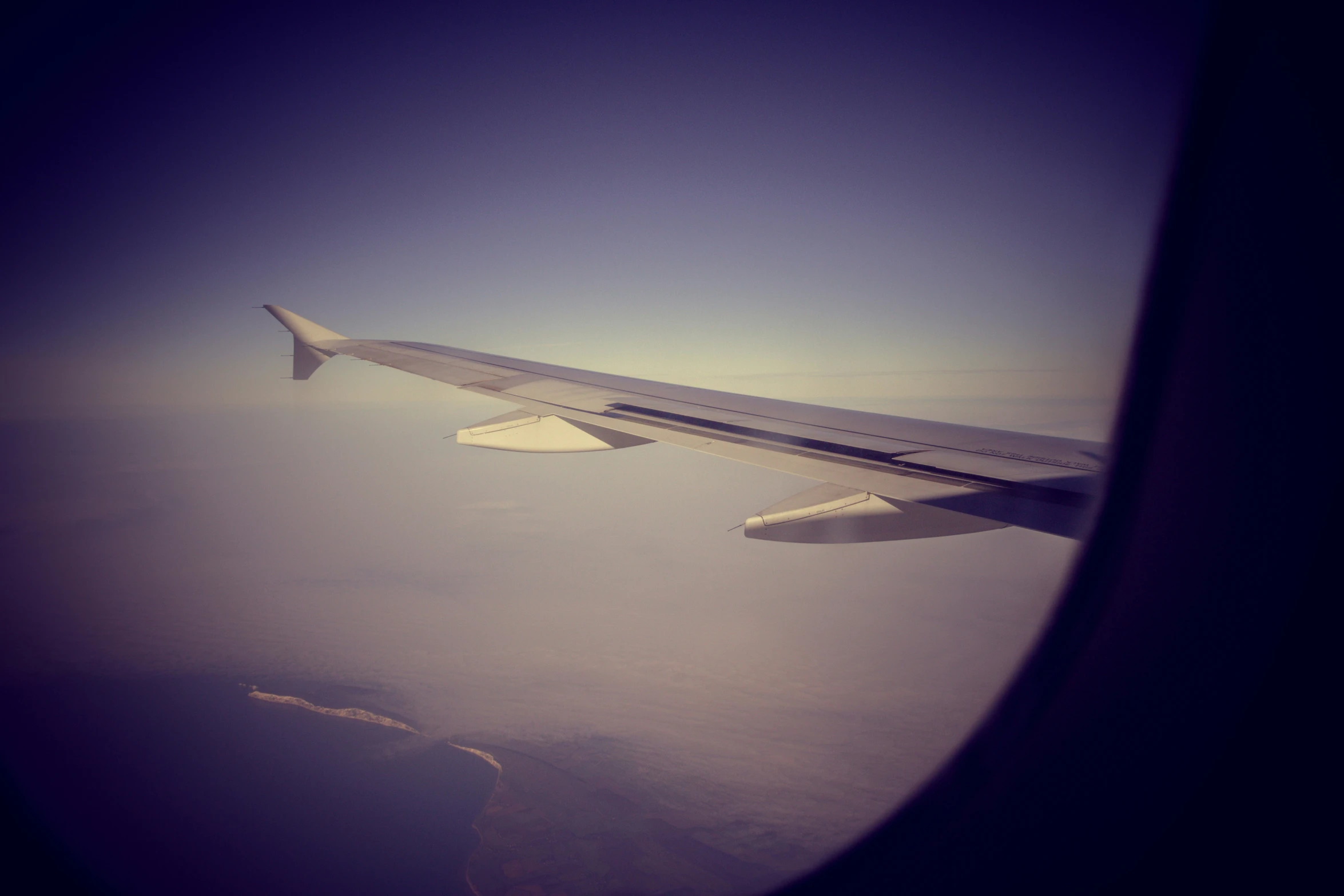 the wing of an airplane flying over land
