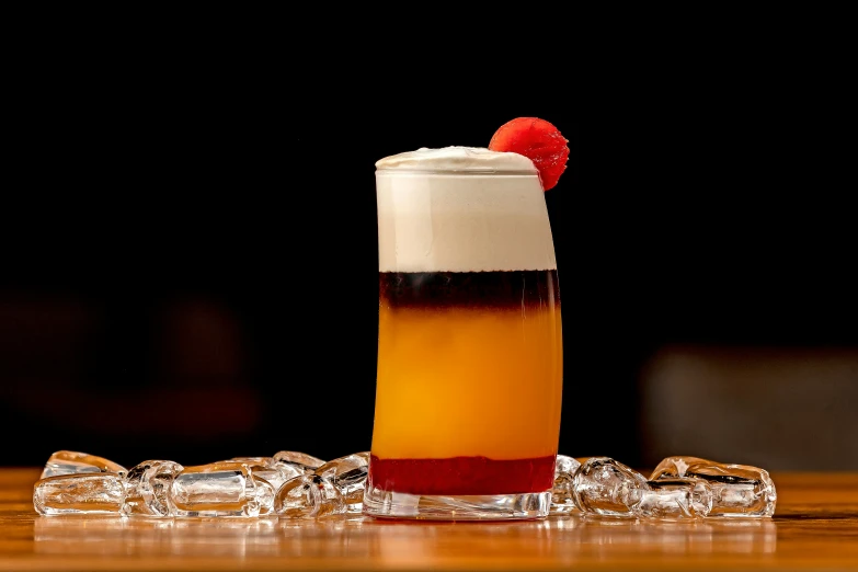 a red berry sticking out of a glass filled with liquid