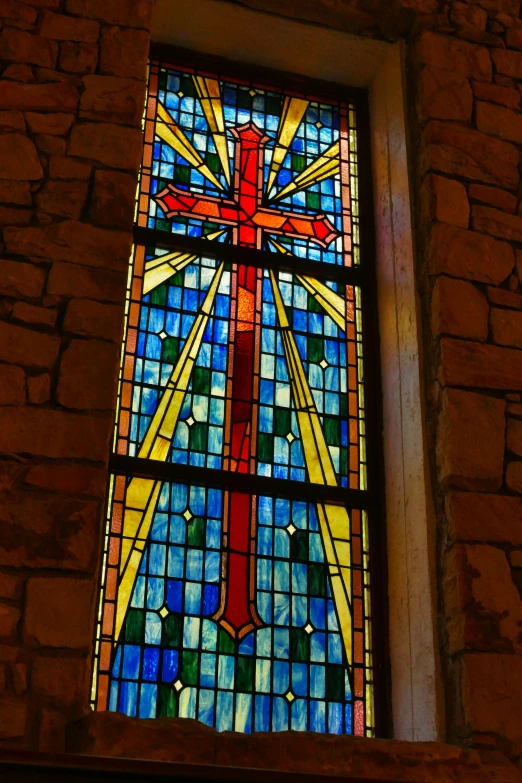 a cross stained glass window inside of a building