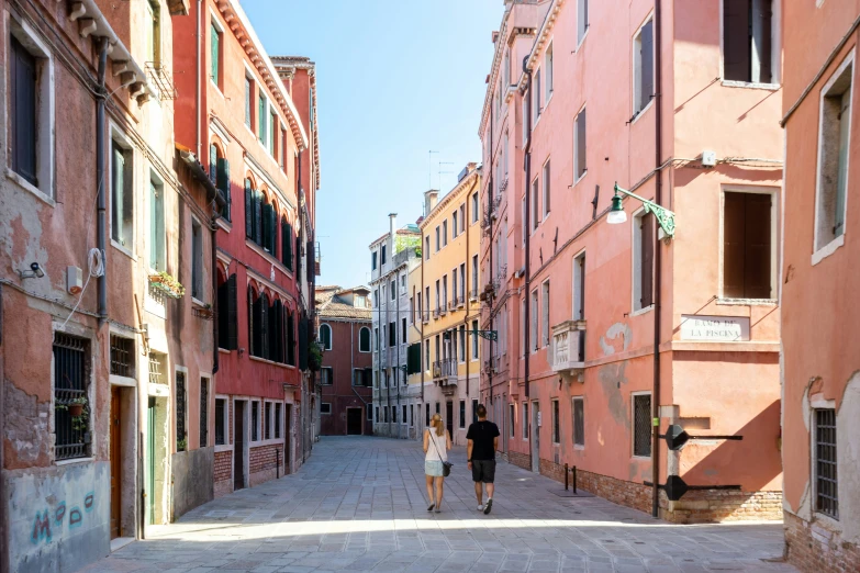 people are walking down the street by buildings