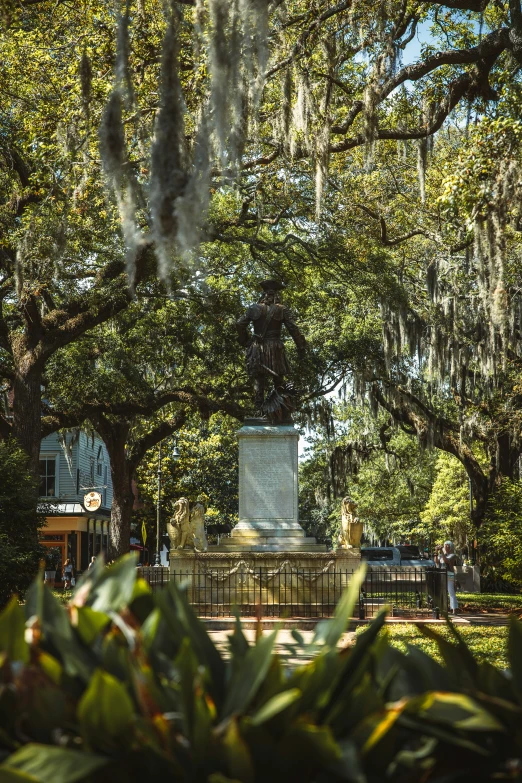 a cemetery surrounded by trees with a stone memorial