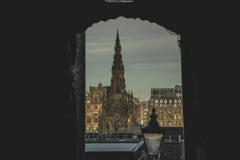 a tall tower is viewed through an arch