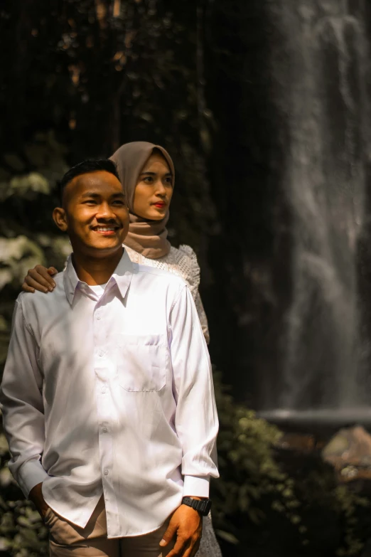 man standing by a waterfall with a woman standing next to him