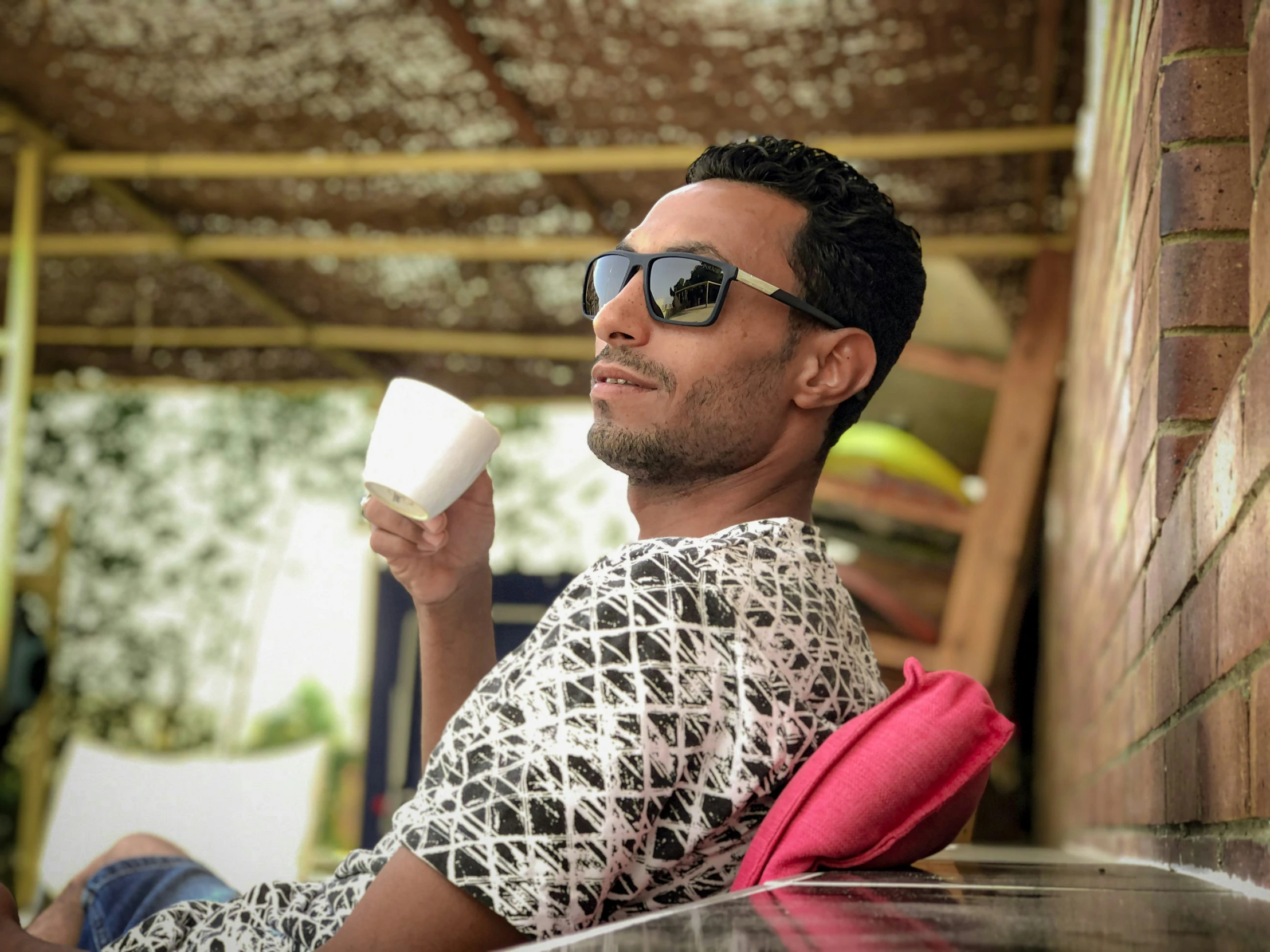 a man with sunglasses on drinking some coffee