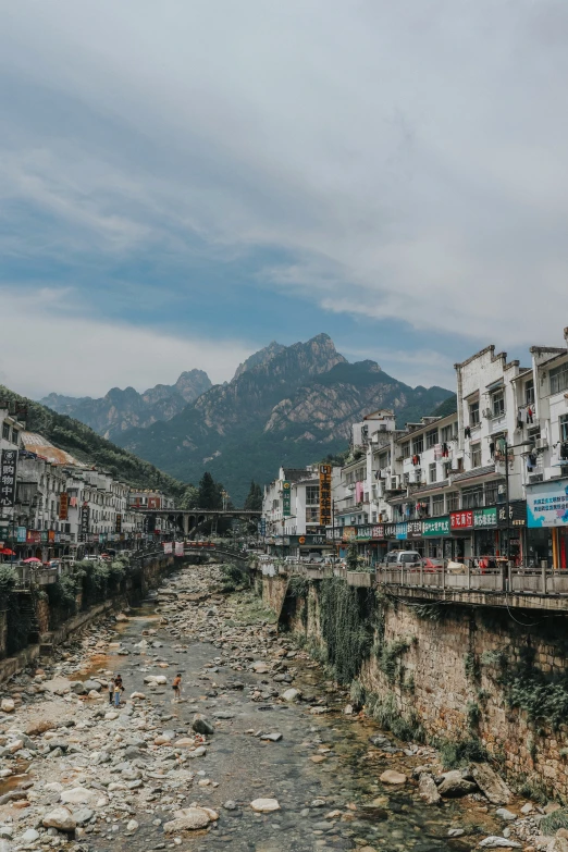 a mountain town is on the side of a river