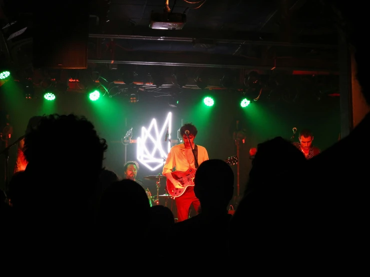 a band plays on stage with the lights turned green