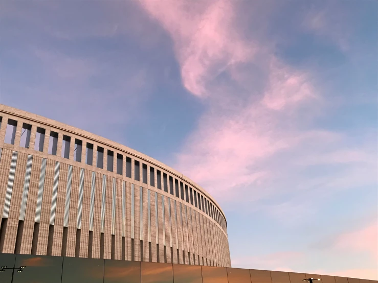 clouds are above a modern building and some traffic lights