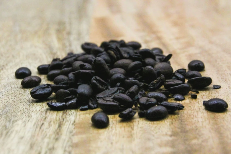some black beans sitting on top of a wooden table