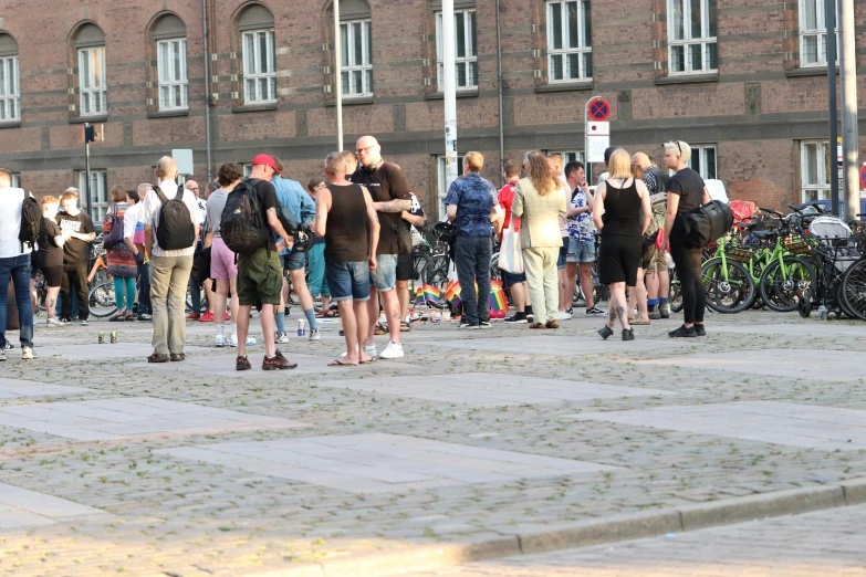 a crowd of people standing outside with bicycles parked in front