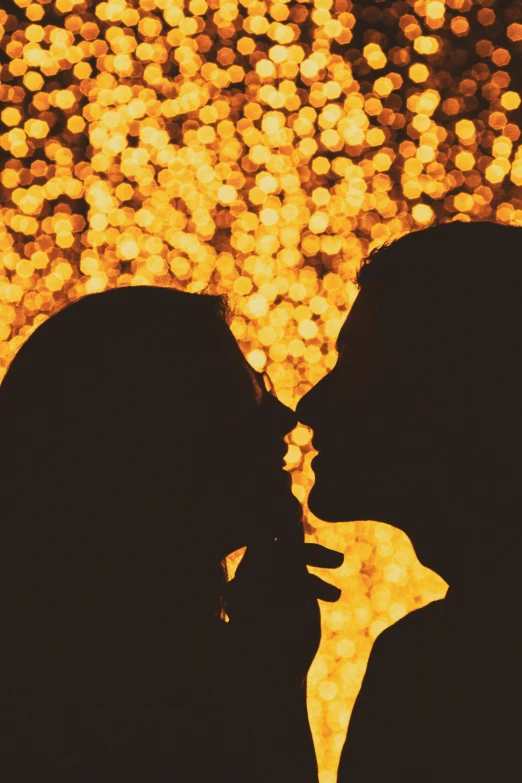 the silhouette of a couple kissing by a firework display