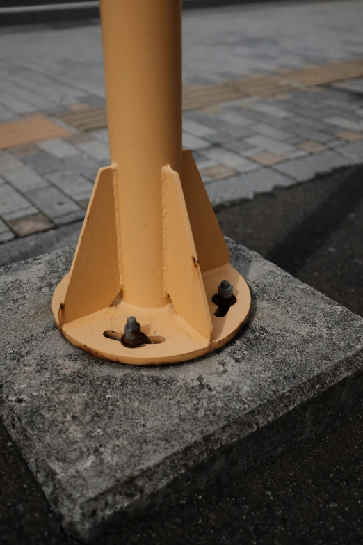 a yellow pole that is sitting on concrete