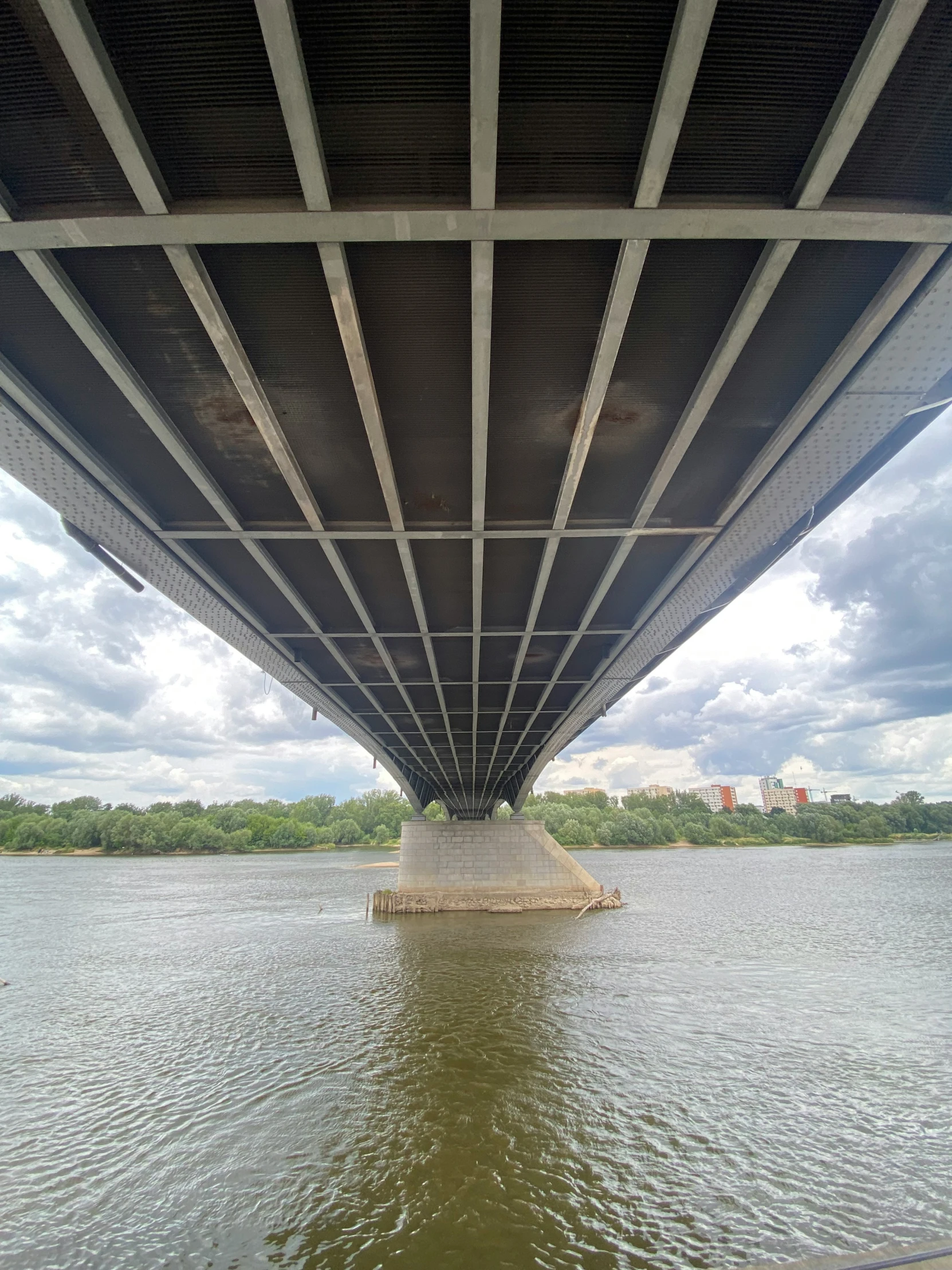 the underside of a large steel bridge spanning water