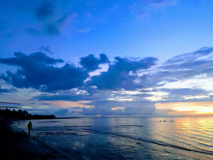 people standing in the shallow water on the beach