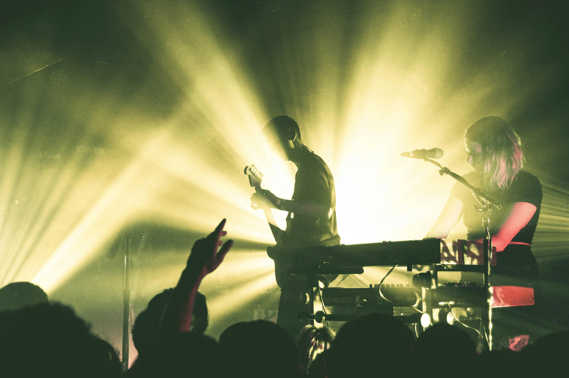 a person at a concert with their hand up in the air