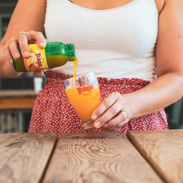 a woman pouring orange juice into a cup