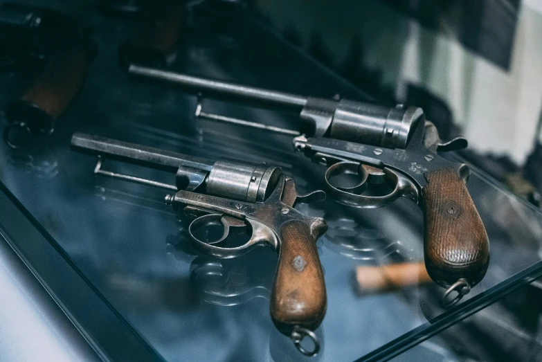 a variety of pistols on display in a museum