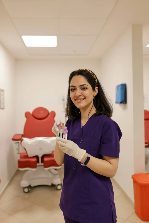 a woman in scrubs and gloves is holding soing