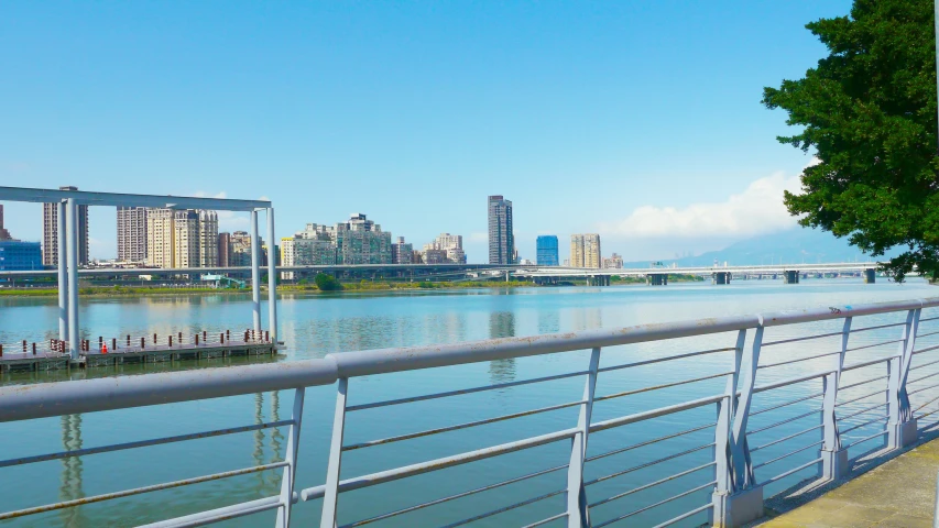 a couple of people stand on a railing by the water