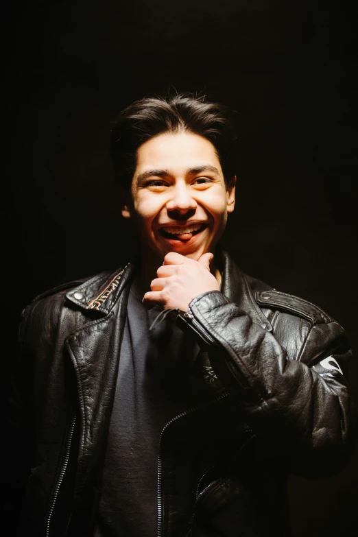 a man that is smiling with a black jacket