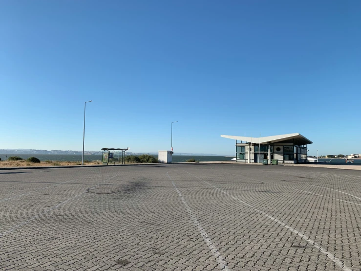 empty parking lot with some light poles and a shelter