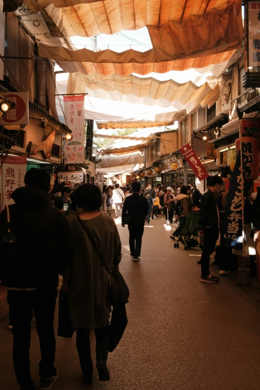 the people are walking down the narrow street