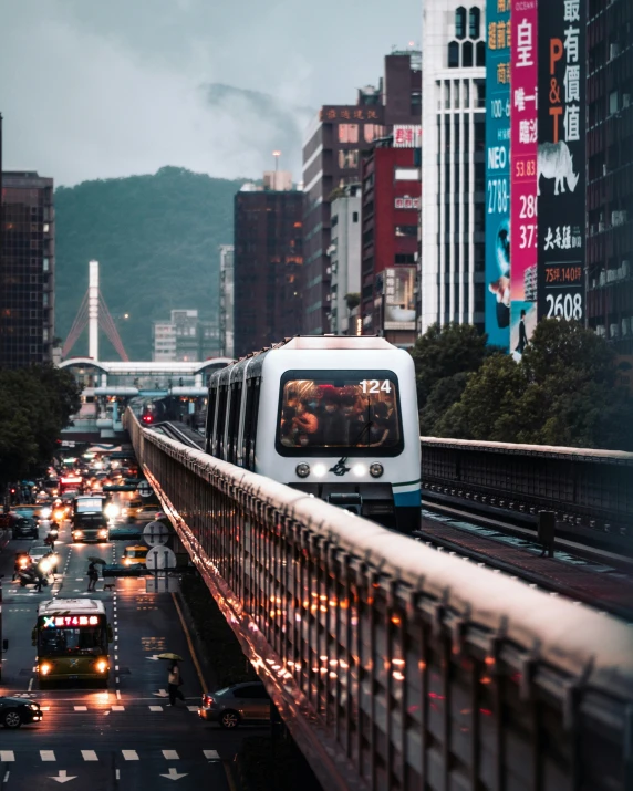 commuter trains and cars moving down a city street