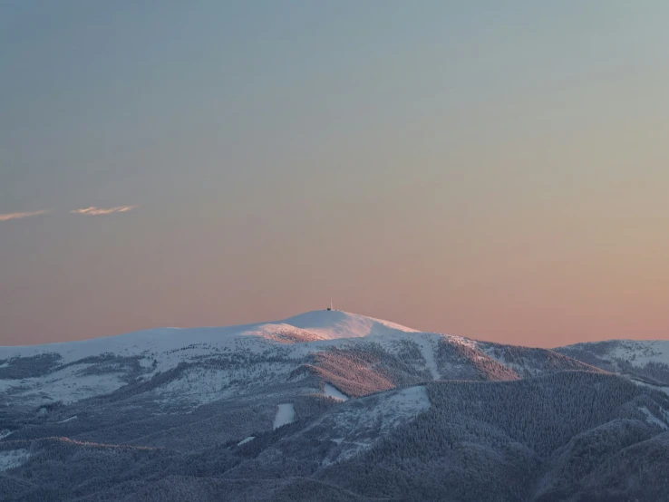 snow covered mountains under an orange and blue sky