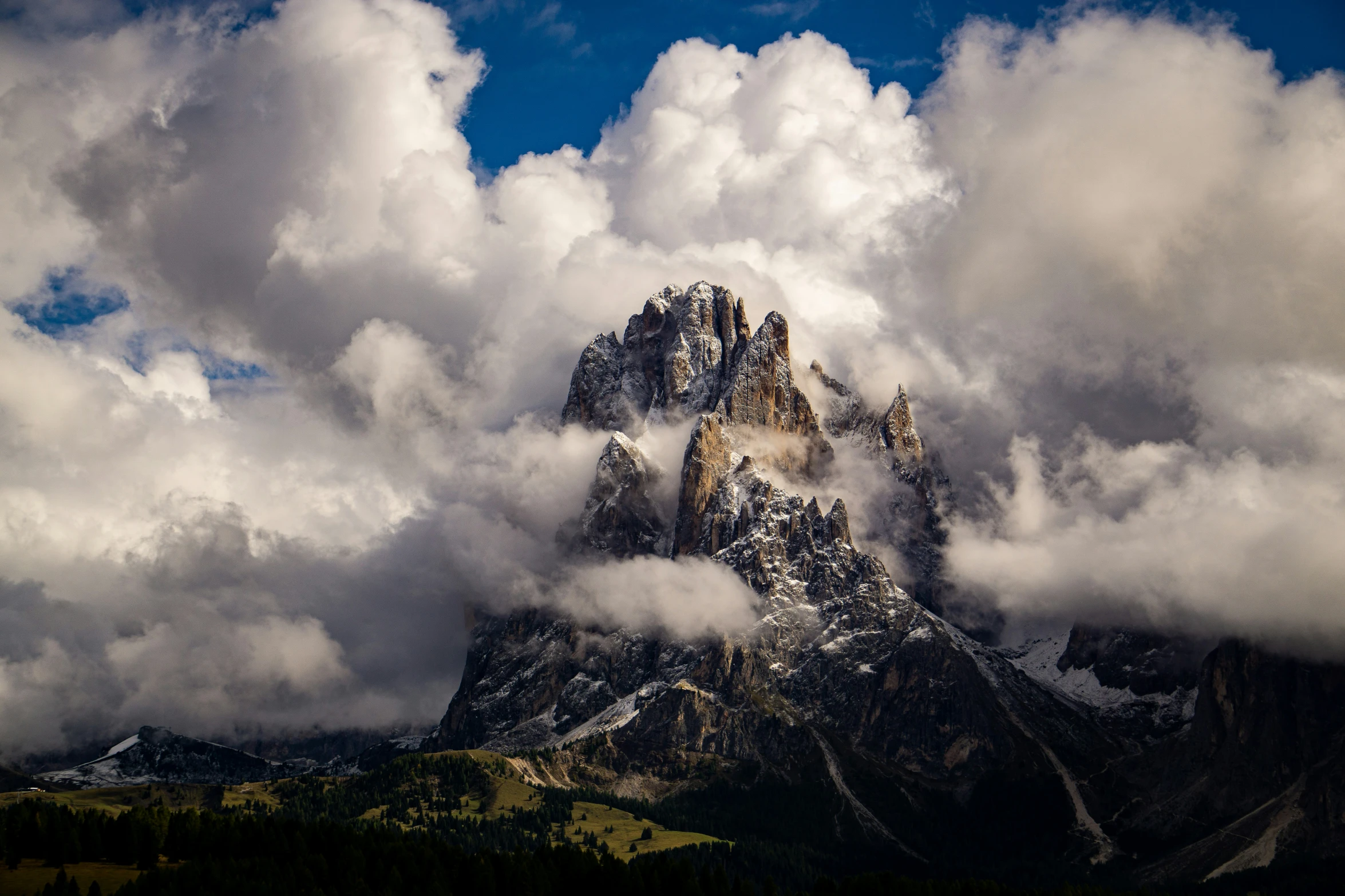 a mountain under some clouds on a sunny day