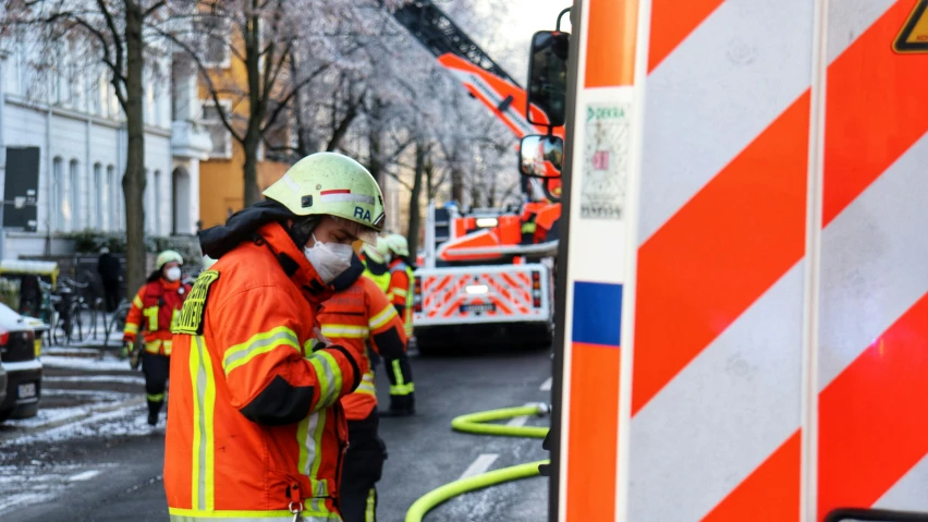 two men in an orange safety jacket, one of them is on the phone