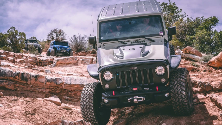 jeeps going down a dirt trail and driving in the background