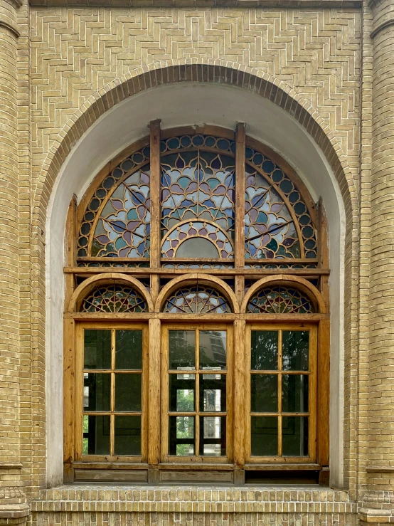 a brick building with stained glass windows and stone walkway