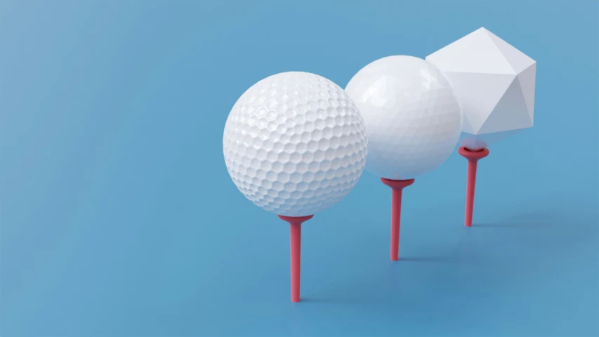 three golf balls lined up on three red tees