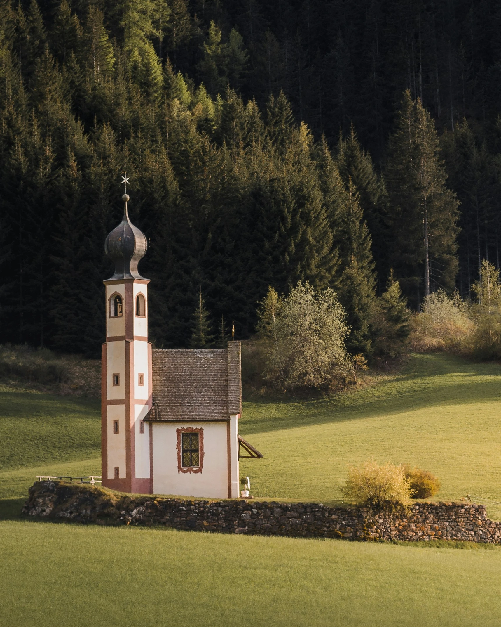 a small church that is in the middle of some grass