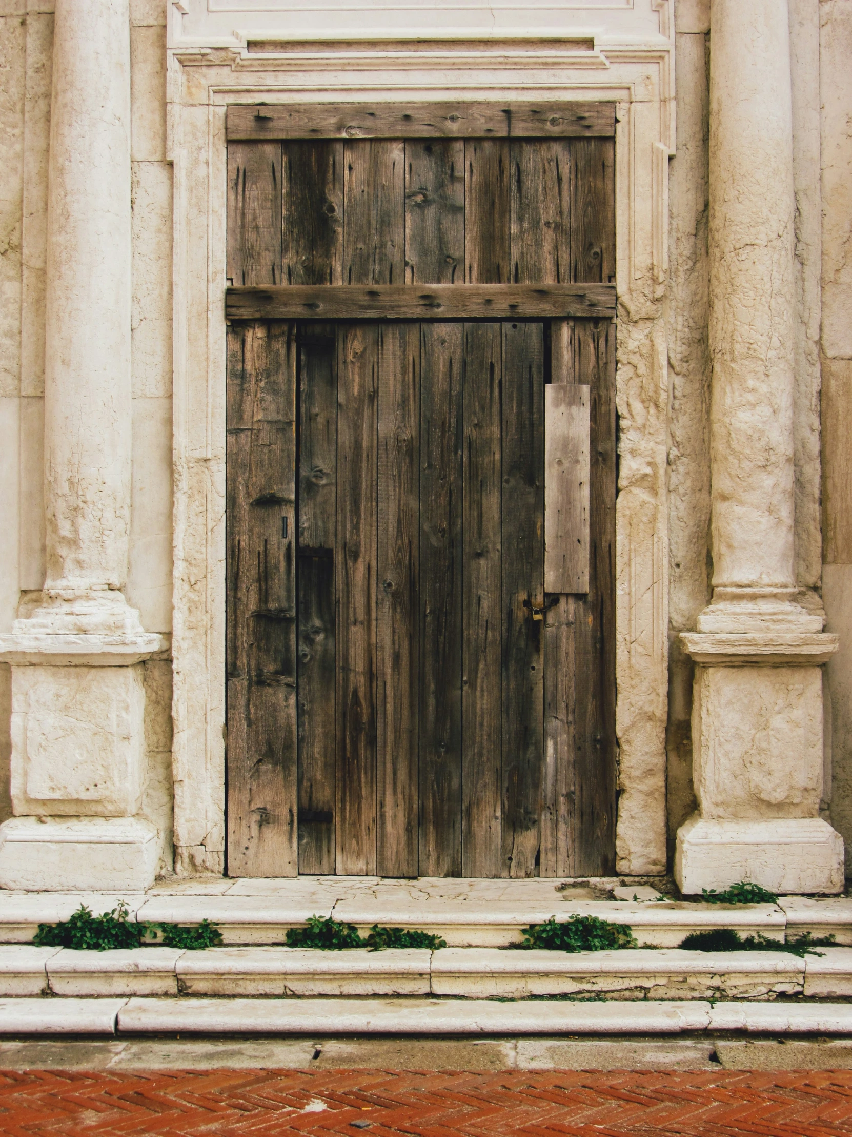 a very rustic door sitting next to a stone building