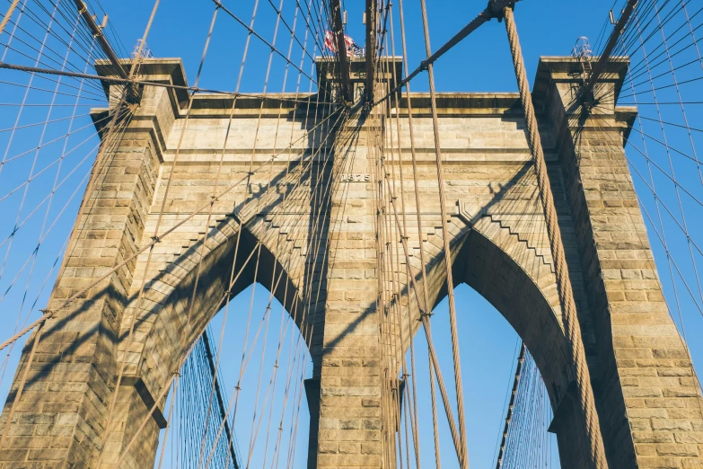 there is a climber on a rope attached to the side of a bridge