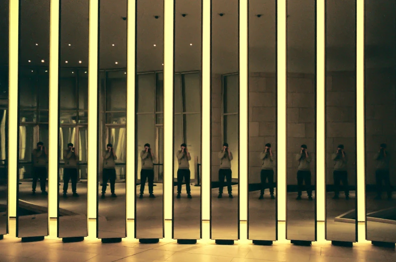 people in a mirror room and reflections on the wall