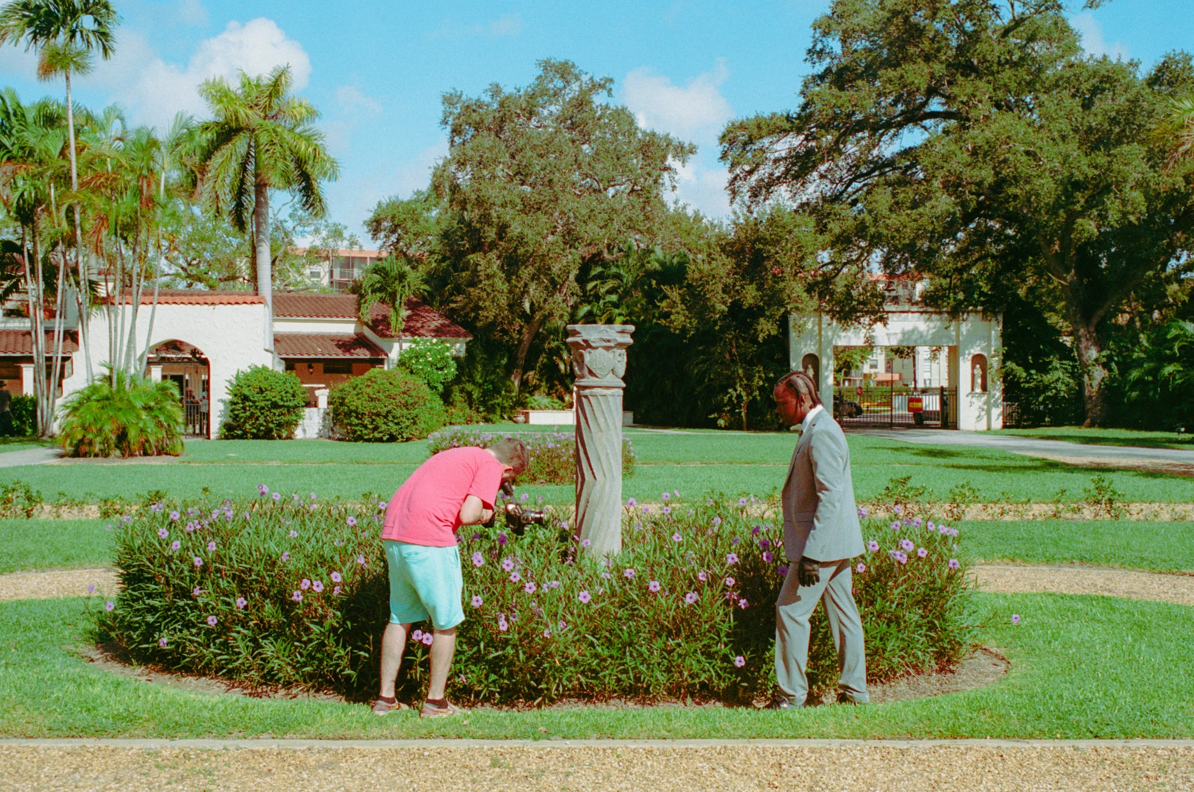 two men are in a small garden tending to plants