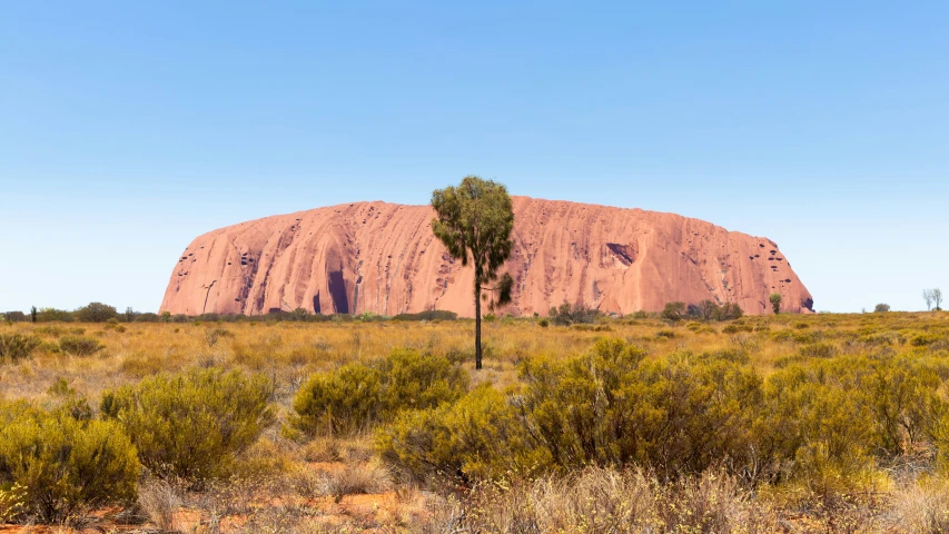 the aye rock towering over a desert landscape