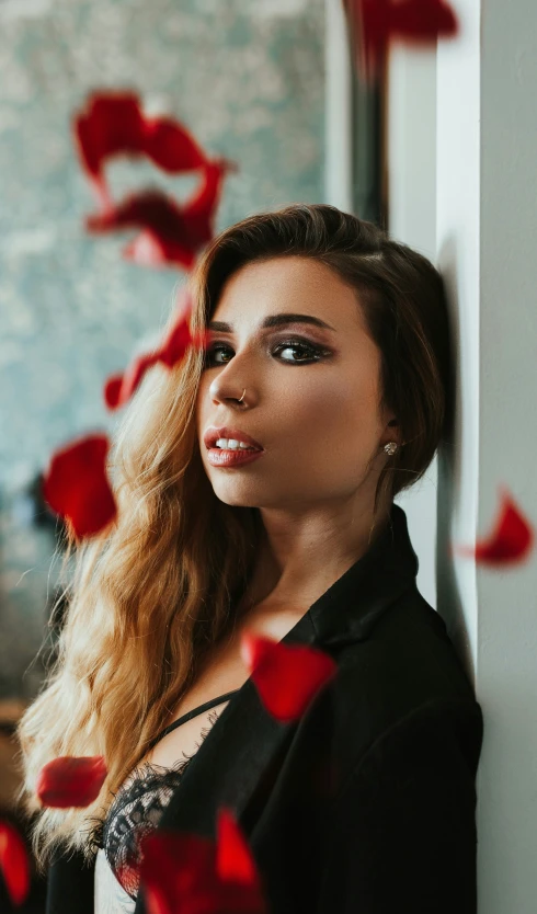 beautiful woman standing by a wall with roses