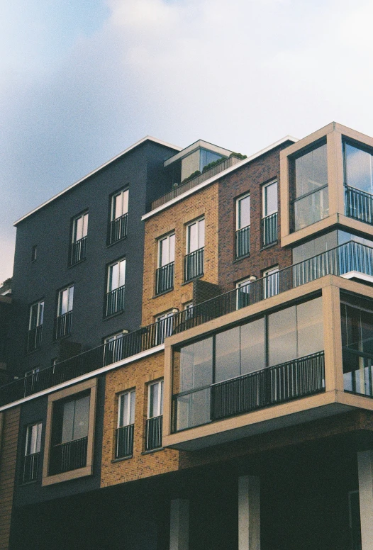 many balconies in an apartment building against a blue sky